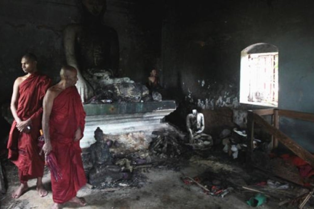 Bangladeshi Buddhist monks look at a Buddhist temple that was torched in Ramu in the coastal district of Cox's Bazaar on October 3. Photo: AP