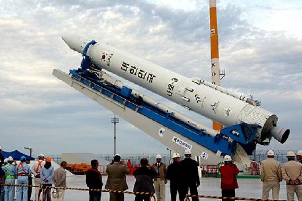 Engineers and launch coordinators gather near the Korea Space Launch Vehicle-I (KSLV-I) on its launch pad on Wednesday. Photo: AFP