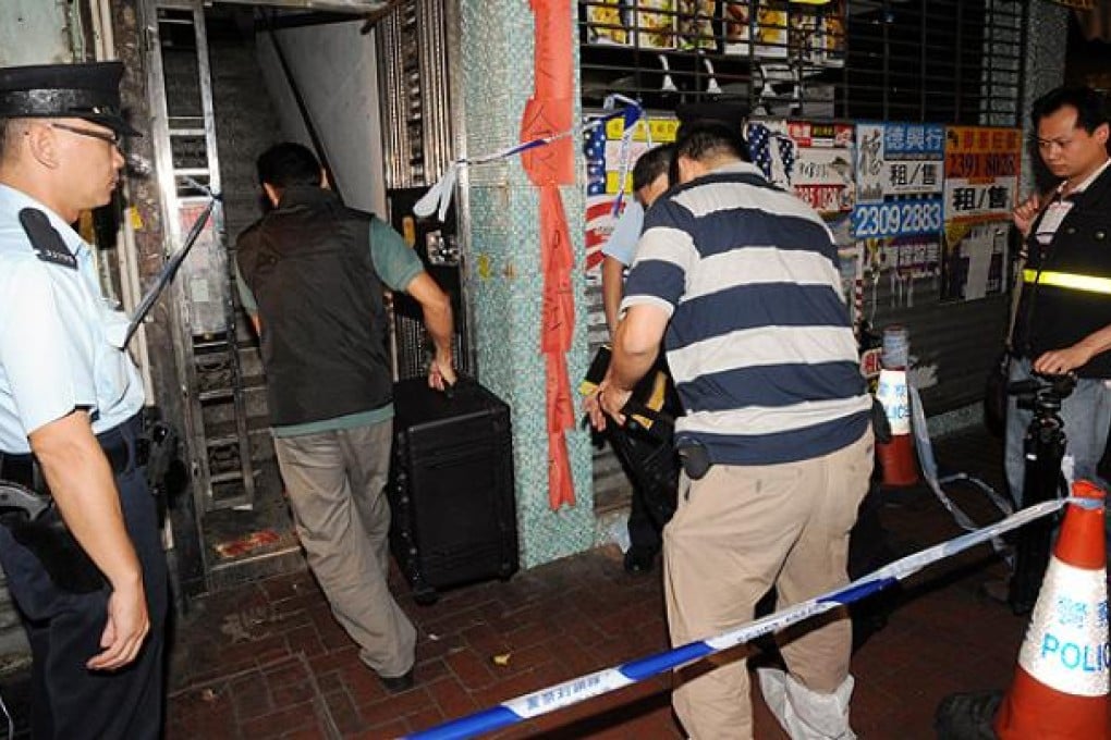 Officers from identification bureau collect evidence in a second-floor flat in Shanghai Street, Yau Ma Tei, where a mainland prostitute was murdered. Photo: SCMP Pictures