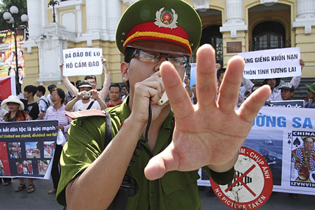 A policeman blocks photographers from taking pictures during an anti-China protest in Hanoi in July. Photo: Reuters