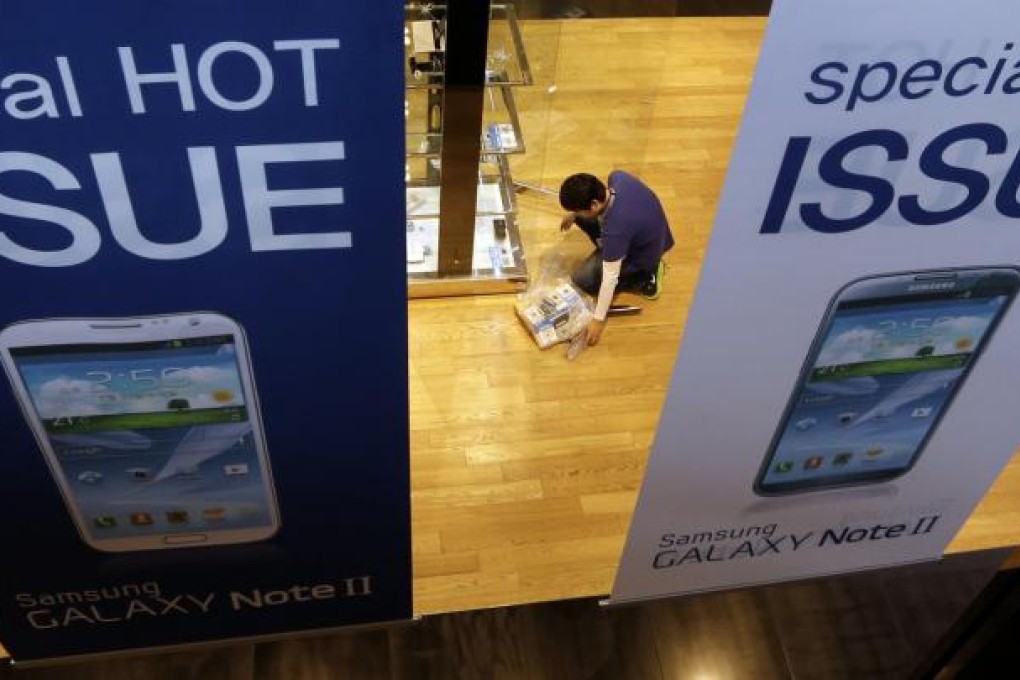 A Samsung employee prepares a showroom display in Seoul. Strong sales of Galaxy phones helped the company's third-quarter net profit nearly double. Photo: AP