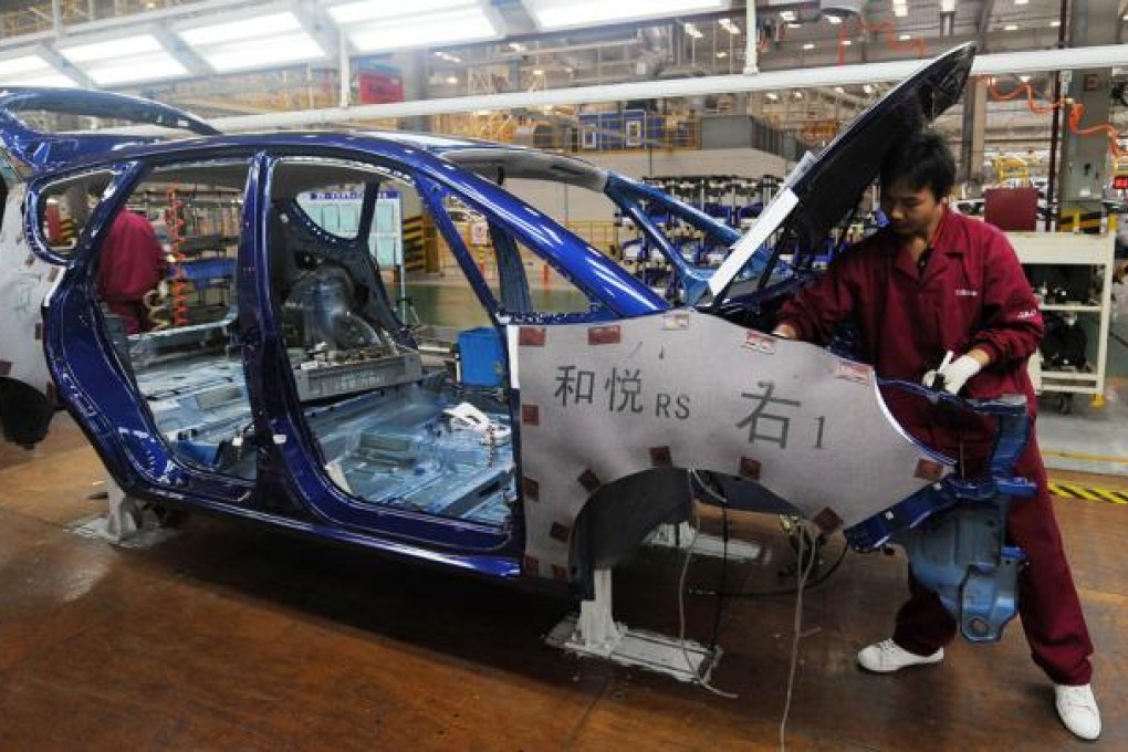 Workers assemble cars at the Jianghuai Auto plant in Hefei, east China's Anhui province. Photo: AFP
