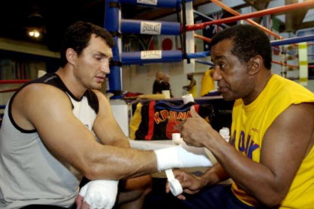 Heavyweight champion Wladimir Klitschko getting his hands taped by trainer Emanuel Steward before a workout at the La Brea Boxing Academy in Los Angeles. Steward has died. He was 68.