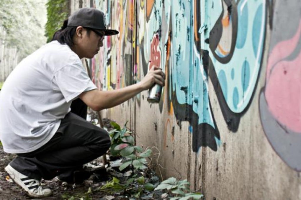ANDC, a member of the ABS Crew, fills in details on a mural on Jingming Lu, near Jiantai Bridge. Photos: Laura Fitch