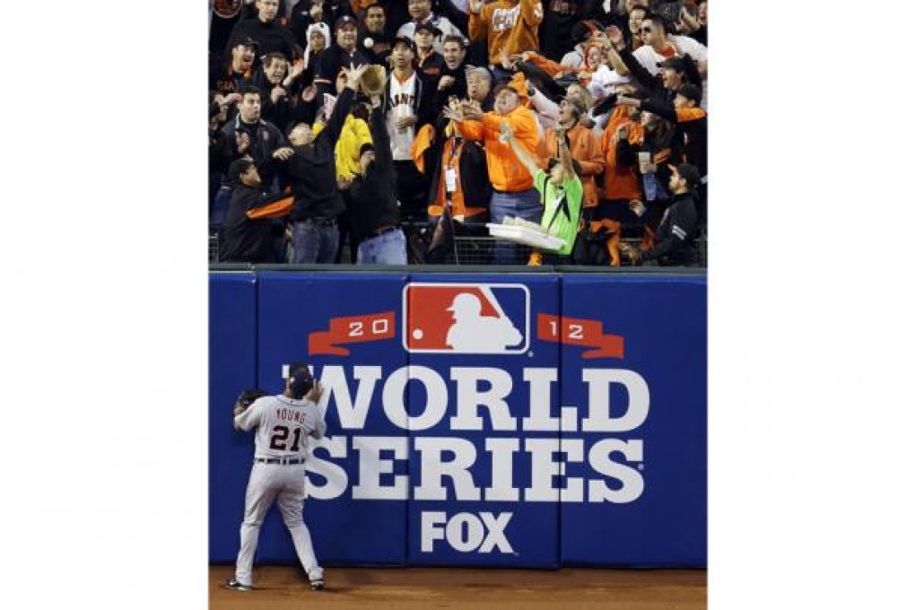 The Detroit Tigers' Delmon Young can only watch as fans go after a two-run home-run ball hit by the San Francisco Giants' Pablo Sandoval, who went on to hit a total of three home runs in the World Series game. Photo: AP