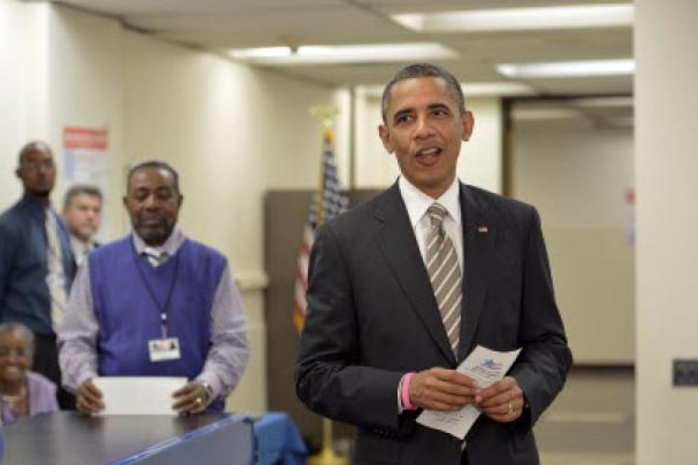 US President Barack Obama holding his Early Voting Ballot Receipt before casting his early vote at the Martin Luther King Community Center in Chicago. Photo: AFP