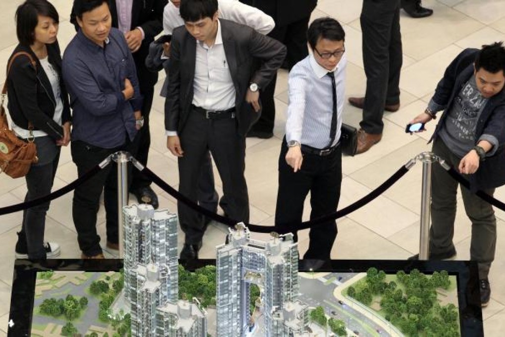 Prospective buyers study a model of The Reach at its sales office in the Miramar Shopping Centre yesterday. Photo: K.Y. Cheng