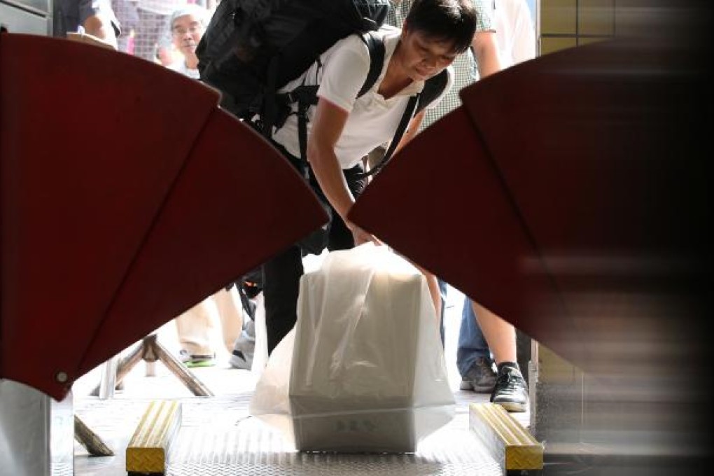 Passengers weigh their baggages on an electronic scale at Sheung Shui train station. Photo: K.Y. Cheng