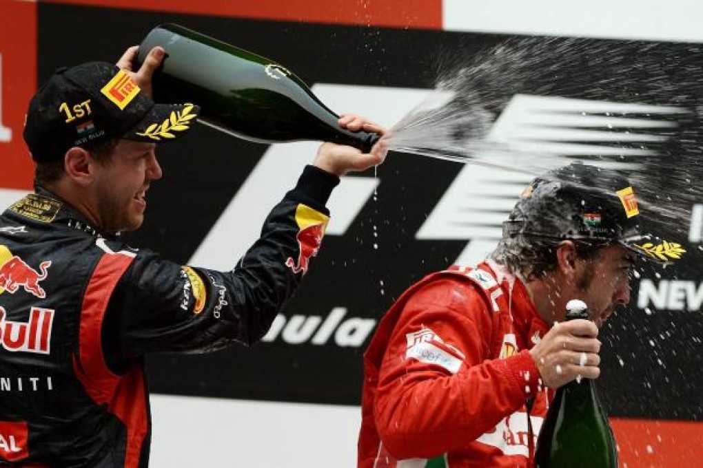 Sebastian Vettel pours champagne on Fernando Alonso. Photo: AFP