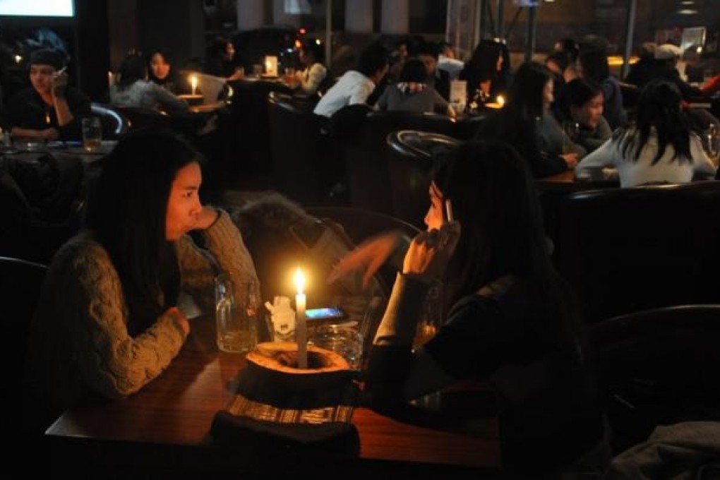 Patrons enjoy a drink and a cigarette in an Ulan Bator bar. From next year, doing so will carry a hefty fine. Photo: Michael Kohn