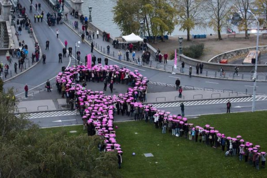 Demonstrators in Budapest form a giant pink ribbon, the international symbol of the fight against breast cancer, during a cancer awareness campaign in Hungary. Photo: EPA