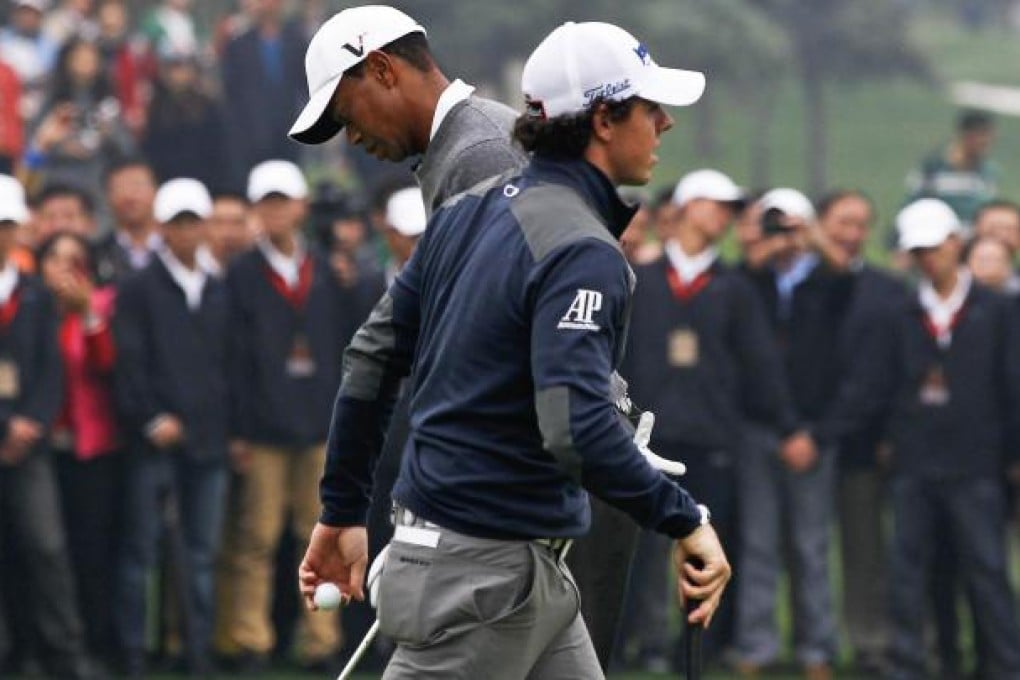 Tiger Woods and Rory McIlroy cross paths on the 10th green during their exhibition showdown at the Lake Jinsha Golf Club in Zhengzhou yesterday. Photo: AFP