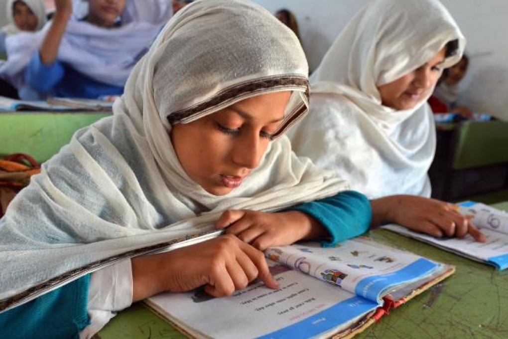 Pakistani girls study at a school in Peshawar, Pakistan. From 1993 to 2010, the number of girls enrolled in primary education increased from 3.7 million to 8.3 million. Photo: AFP