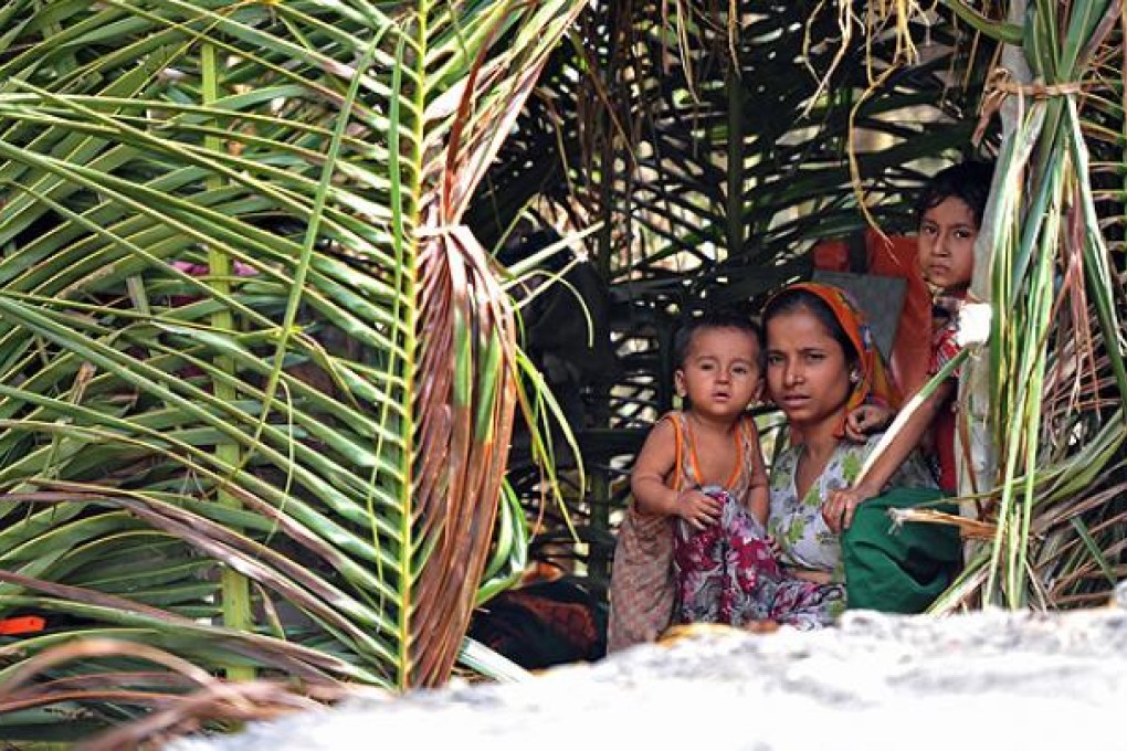A Muslim Rohingya woman sits with her children in her temporary shelter at a village in Minpyar in Rakhine state. Photo: AFP