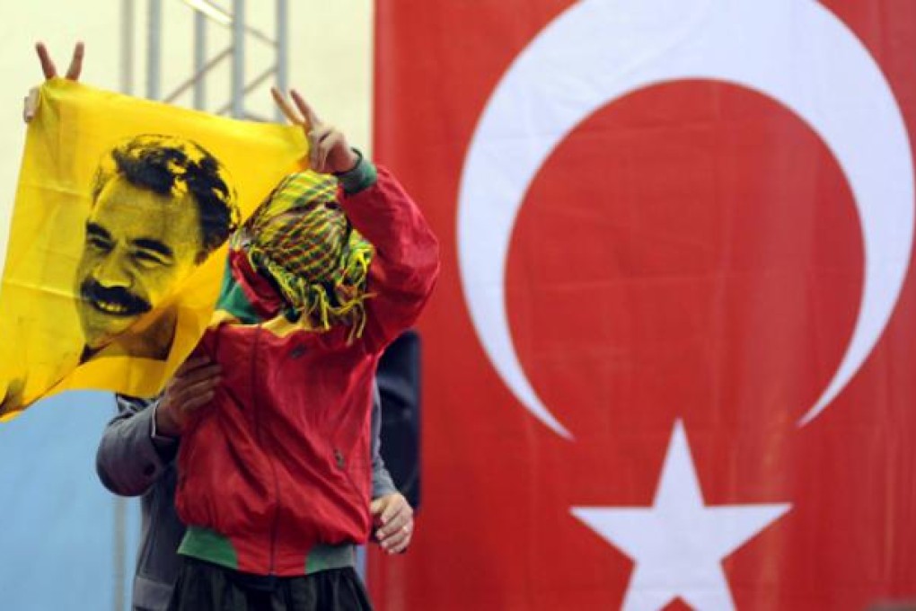 A supporter of the pro-Kurdish Peace and Democracy Party holds a poster of Abdullah Ocalan, the jailed leader of outlawed Kurdistan Workers Party, during the party's congress in Ankara on October 14. Photo: AFP