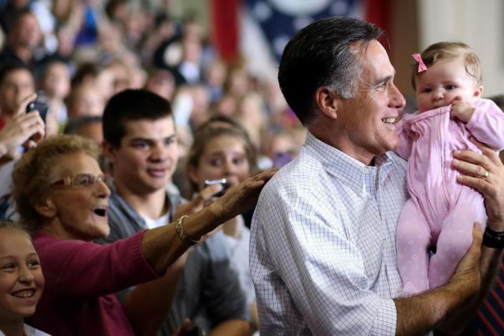 Mitt Romney poses for the obligatory baby photo at a rally in Avon Lake, Ohio, as he steps up his attacks on Barack Obama. Photo: AFP