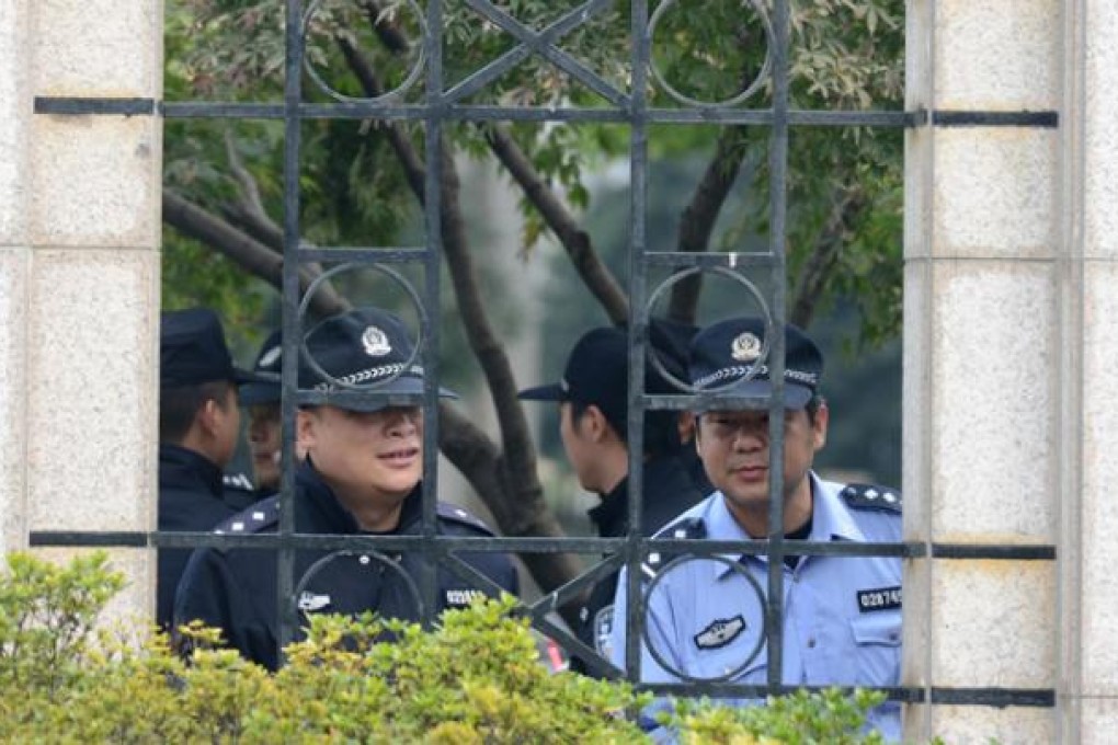 Police look out from the city government offices in Ningbo, in eastern China's Zhejiang province, on Monday after thousands of locals clashed with police during a protest at the construction of a chemical plant. Photo: AFP