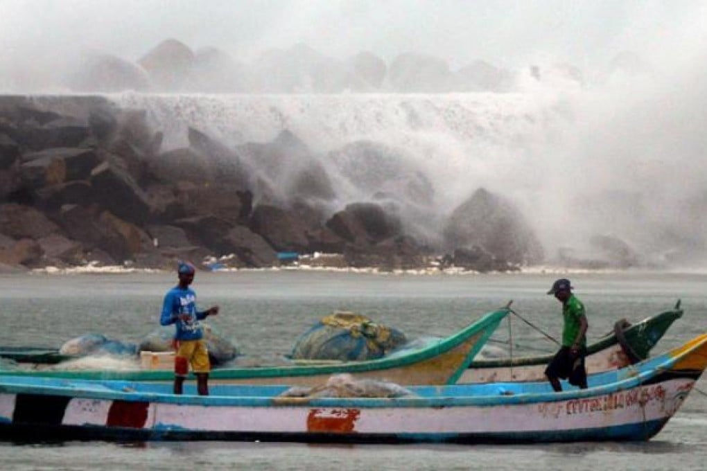 Fishermen stand on their fishing boats at the Kasimedu Fishing Harbour ahead of Cyclone Nilam, in Chennai, on Wednesday. Photo: EPA