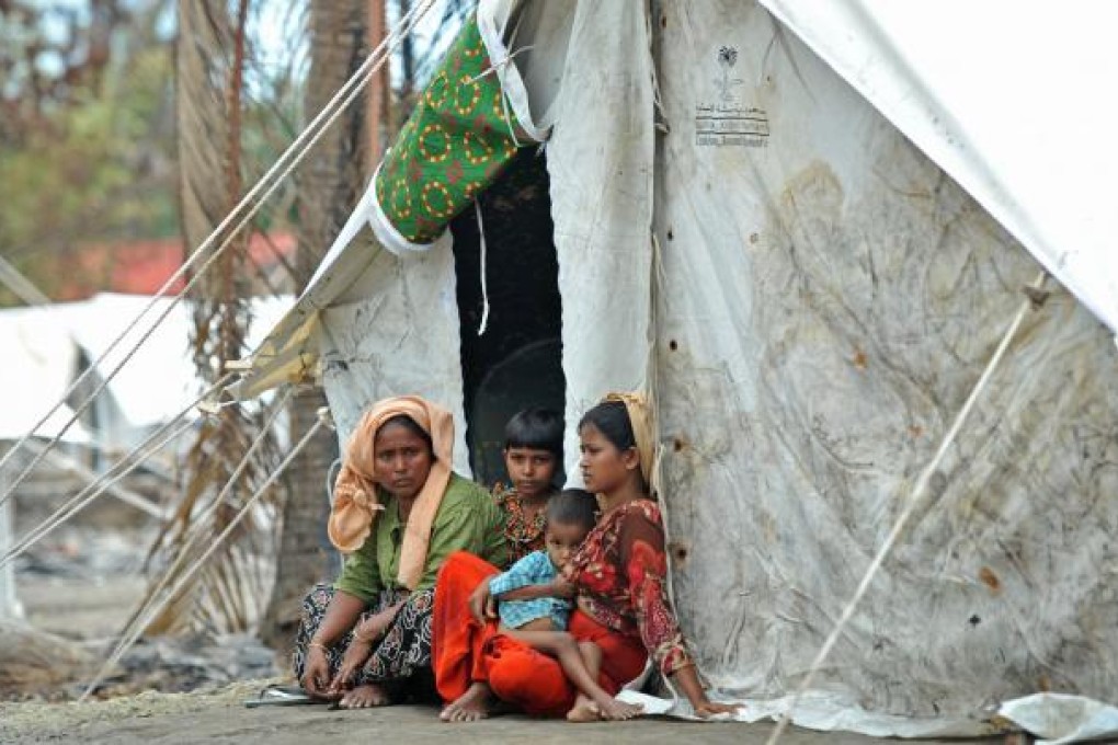 A Muslim Rohingya family sits outside their temporary shelter at a village in Minpyar, Rakhine state. At least 88 people have been killed in sectarian violence this month, with more than 26,000 others forcefully displaced. Photo: AFP