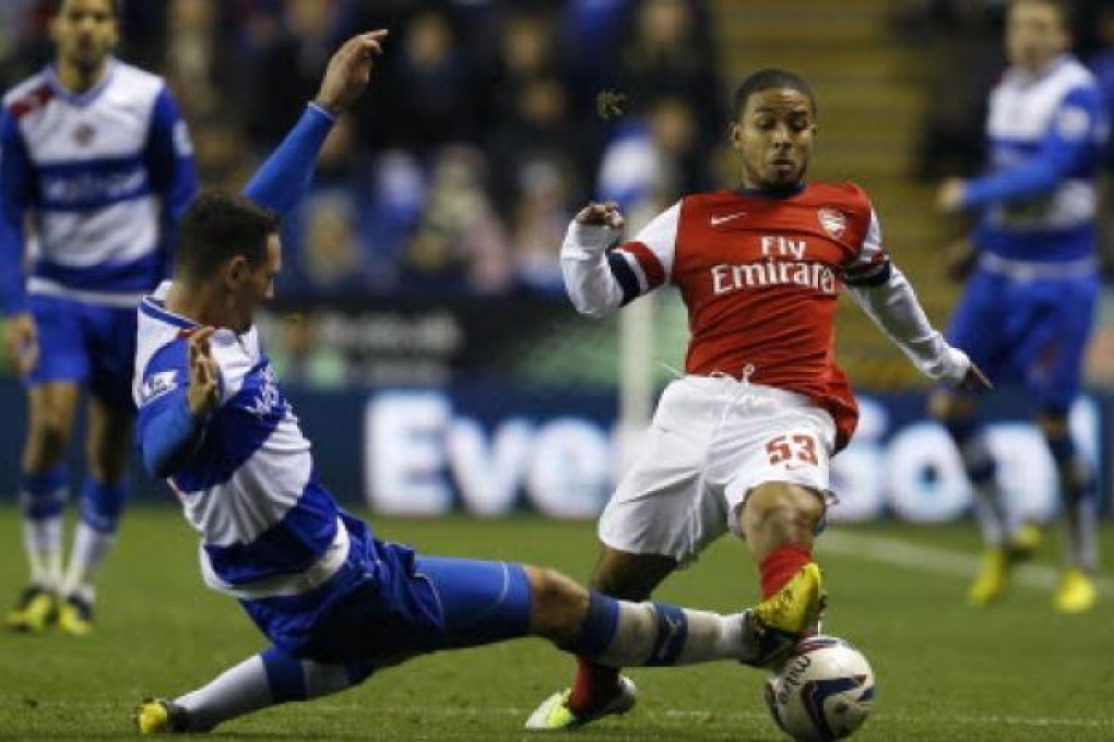 Reading's Sean Morrison, left, vies for the ball with Arsenal's Jernade Meade during the English League Cup soccer match between Reading and Arsenal at Madejski Stadium in Reading. Photo: AP