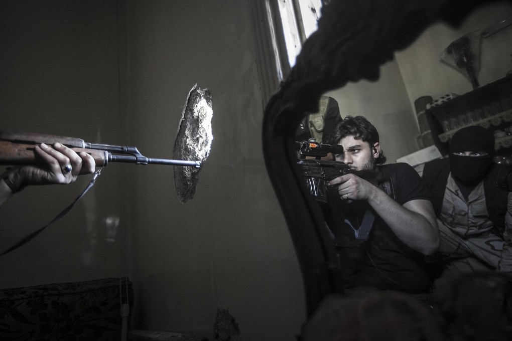 A rebel sniper aims at a Syrian army position in the Jedida district of Aleppot. Photo: AP