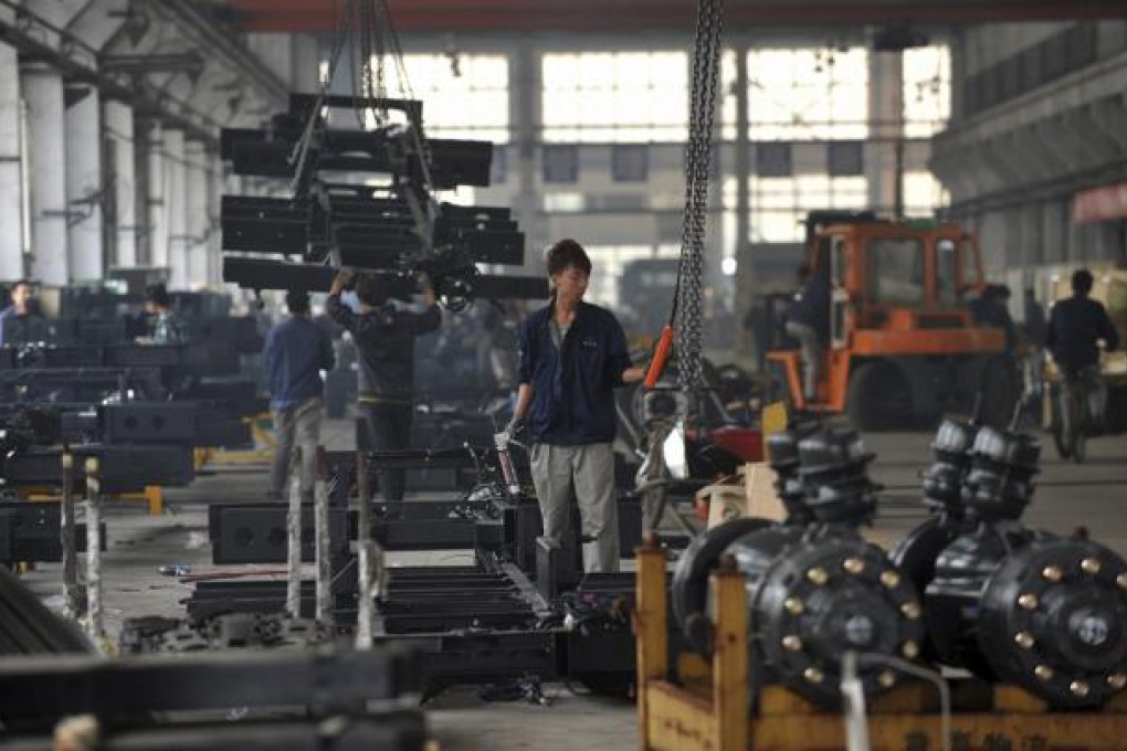 A worker prepares to hoist metal parts at the assembly line at a bus manufacturer in Dandong city in northeast China's Liaoning province on Oct. 20, 2012. Photo: AP