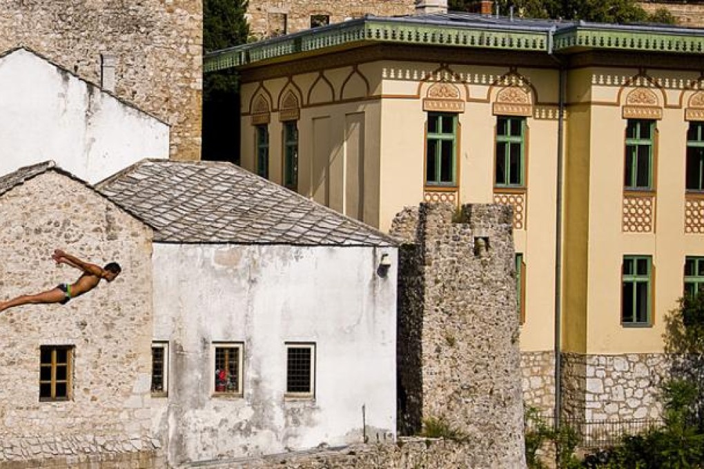 A diver takes the plunge from the new Old Bridge