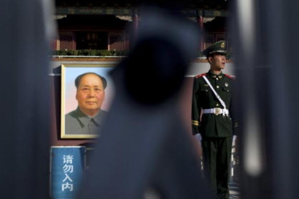 A Chinese paramilitary policeman stands guard near the portrait of Communist leader Mao Zedong at Tiananmen Gate in Beijing Thursday, Nov. 1, 2012.Photo: AP