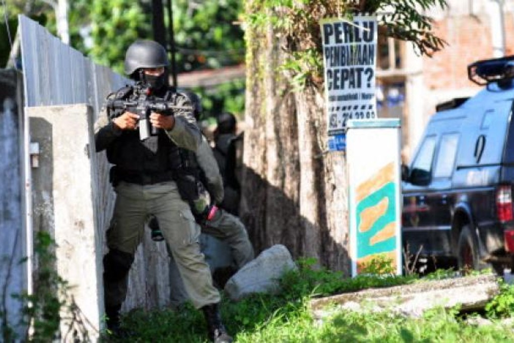 Indonesian anti-terro police, Densus 88, prepare to secure downtown Poso in Central Sulawesi province on Saturday in an effort to raid a terror suspects house. Photo: AFP