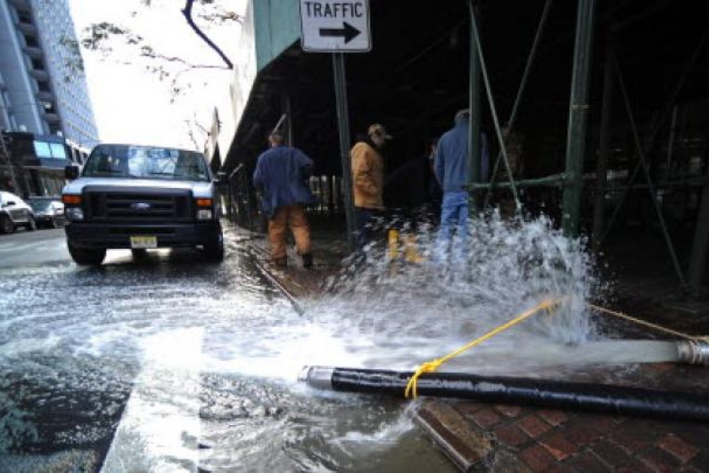 Workers continue to pump flood waters from a building, caused by Hurricane Sandy in New York on Friday. Photo: EPA