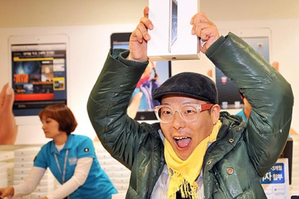 A South Korean customer gets his hands on an iPad mini on Friday in Seoul. Photo: AFP
