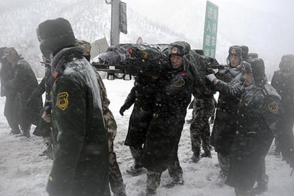 Police evacuate a man who was trapped when hundreds of vehicles were blocked by heavy snow on an expressway in Yanqing county near Beijing. Photo: AP