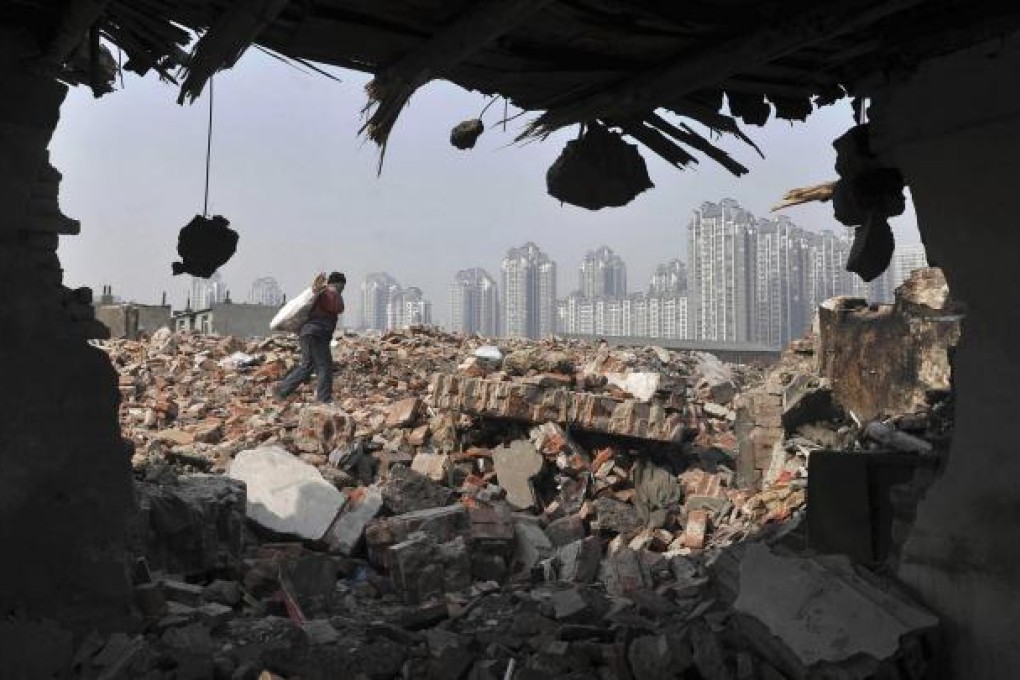 A man carries wood from a Shenyang demolition site. Photo: Reuters