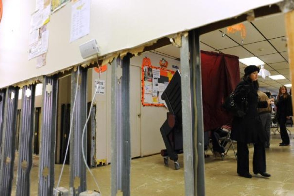 A woman leaves an election booth in Hoboken, where ballots were cast amid hurricane debris. Photo: EPA
