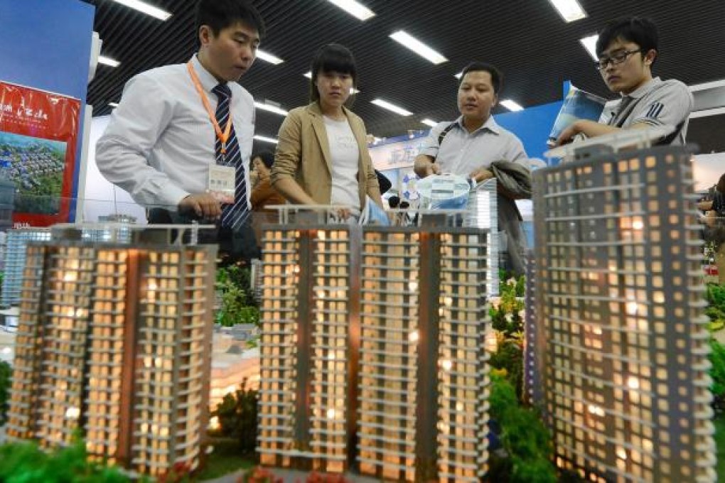 People view a model of a Beijing development. Demand for luxury property fell after curbs made it harder to get mortgages. Photo: AFP