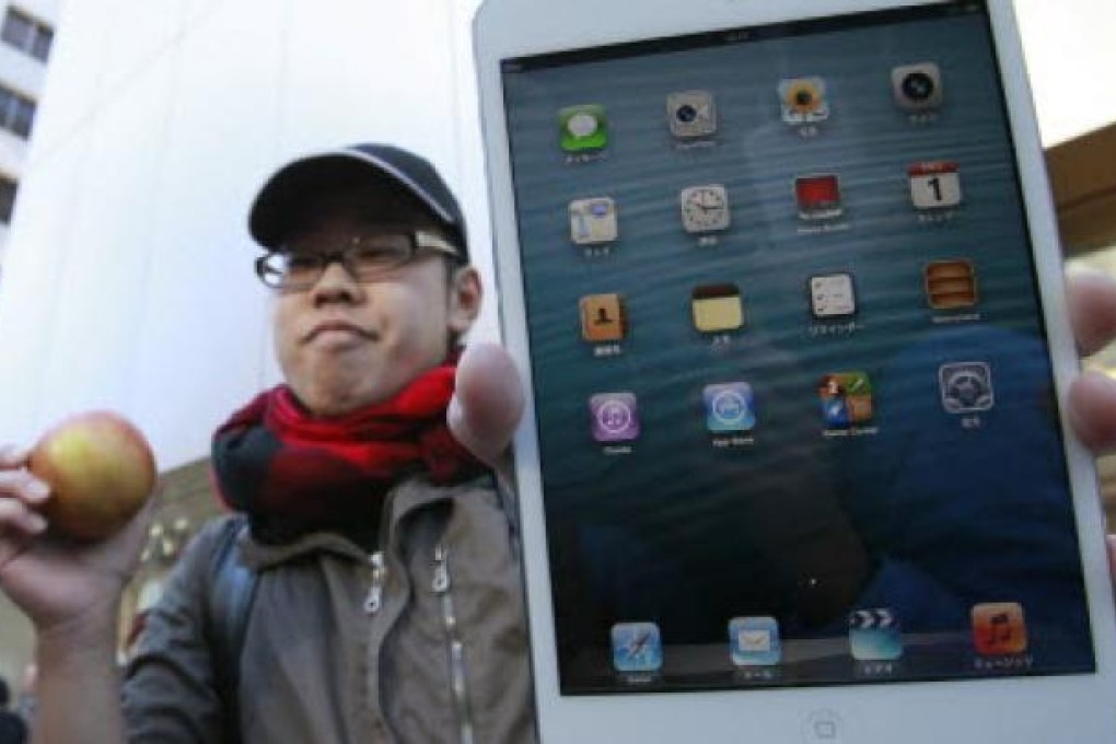 A happy customer shows off his newly purchased iPad mini, Apple’s first foray into the smaller-tablet segment, in front of the Apple Store Ginza in Tokyo. Photo: Reuters