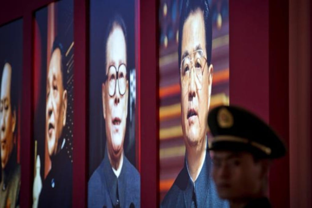 A Chinese paramilitary policeman stands next to a display showing four generations of Chinese leaders, from right, current President Hu Jintao, former President Jiang Zemin, paramount leaders Deng Xiaoping and Mao Zedong during an exhibition entitled "Scientific Development and Splendid Achievements" on Monday. Photo: AP