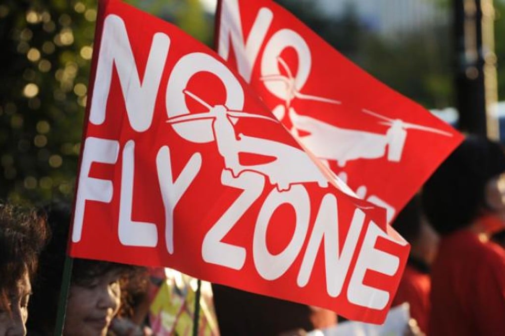 Protesters display "No fly zone" flags featuring US MV-22 Osprey aircraft, during their protest rally against US military bases in Okinawa on October 24. Photo: AFP