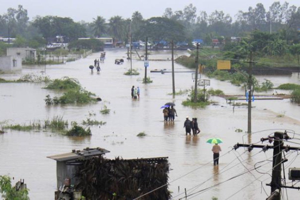 Indian residents wade through flood waters in Visakhapatnam in the coastal district of Andhra Pradesh on Monday. Photo: AFP