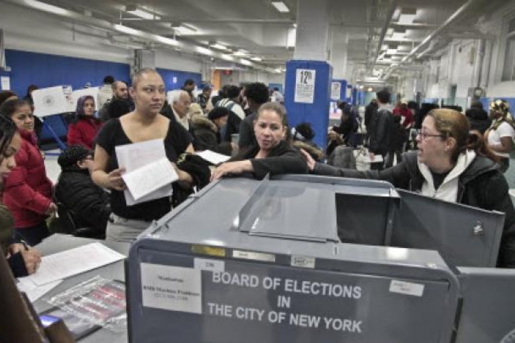 BA poll worker (far right) give instructions to voters arriving from a relocated polling site that closed after flooding from superstorm Sandy, on Tuesday. Photo: AP