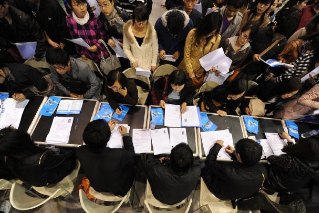 Job seekers line up to hand in their resumes as thousands of people gather at a job fair in Hefei. Photo: AFP