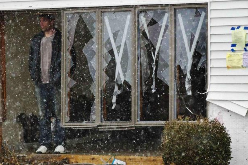 A homeowner in Lindenhurst, New York, watches the arrival of the early winter storm. Photo: Reuters