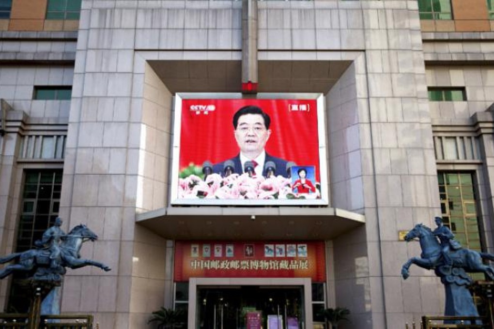 A TV screen at a China Post Office building shows a live broadcast of Chinese President Hu Jintao's speech at the opening session of the 18th Communist Party Congress on Thursday. Photo: AP