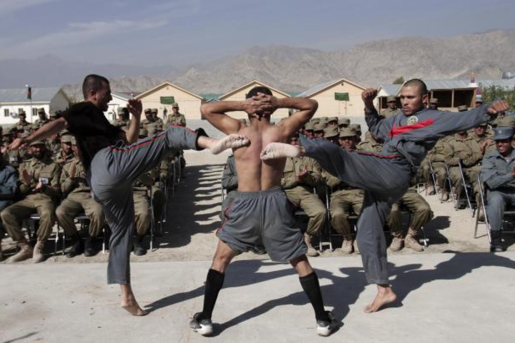 Newly graduated police demonstrate their skills during a graduation ceremony in Laghman province, east of Kabul, on Wednesday. Photo: AP