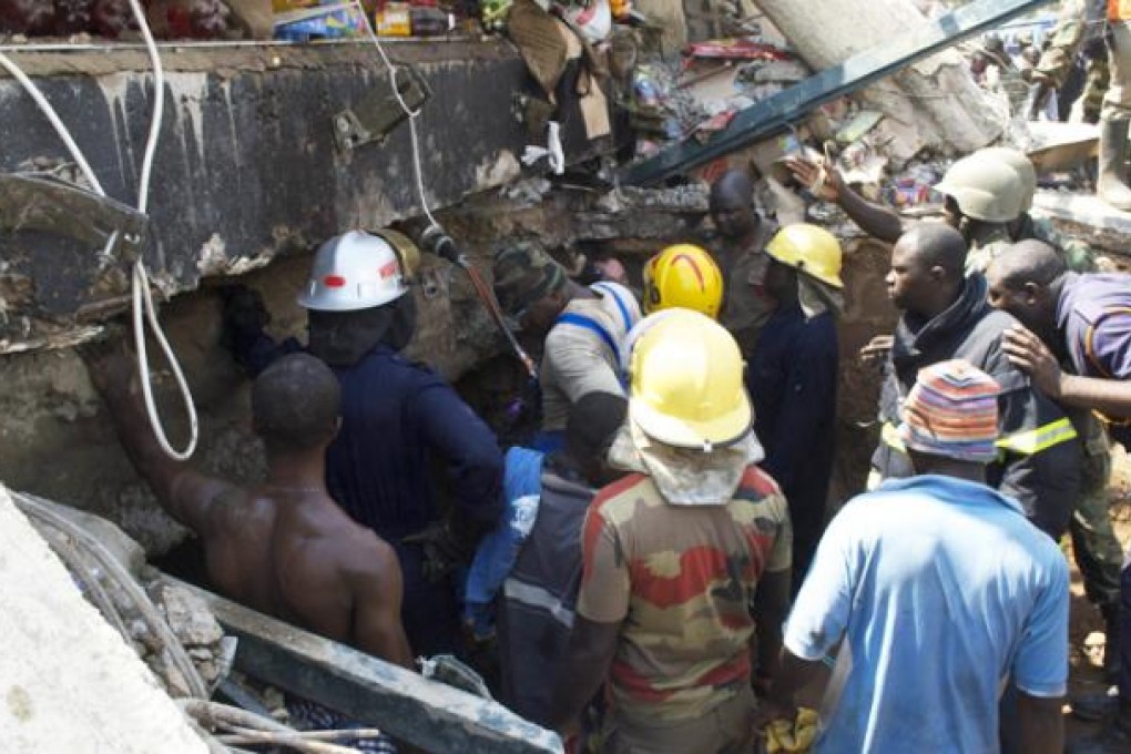 Rescue workers drill into the roof of a collapsed shopping mall that killed at least seven people and trapped dozens of others on Wednesday in Accra. Photo: AFP