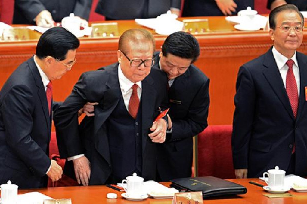 Hu Jintao (left) helps former leader Jiang Zemin stand. Photo: AFP