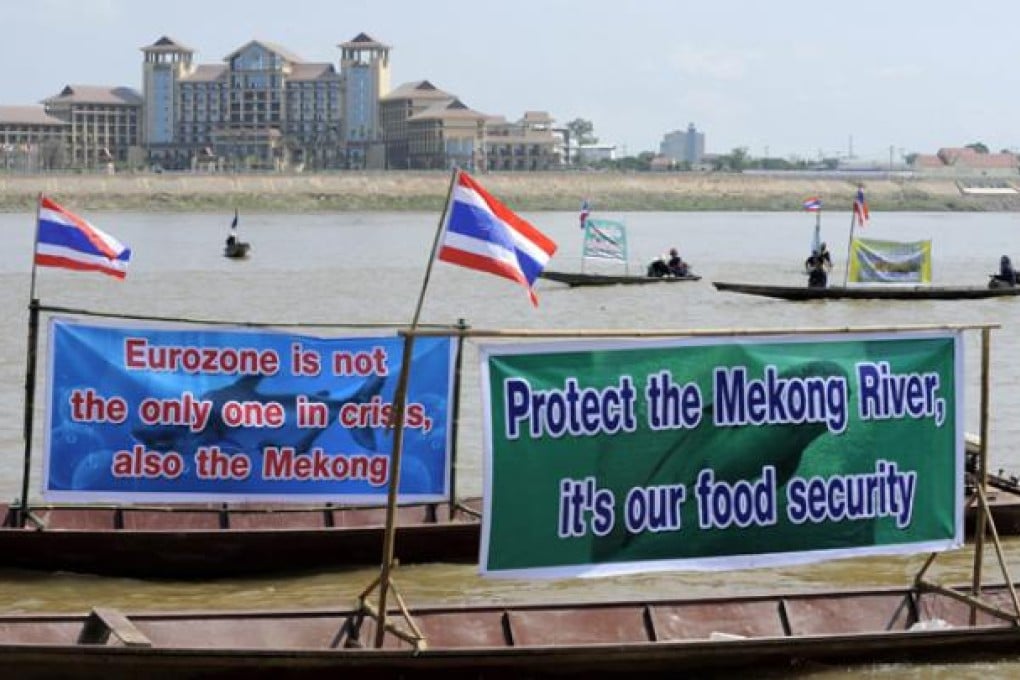 Thai activists and villagers who are affected by the controversial Xayaburi dam protest with with banners on the Mekong riveron Monday. Photo: EPA