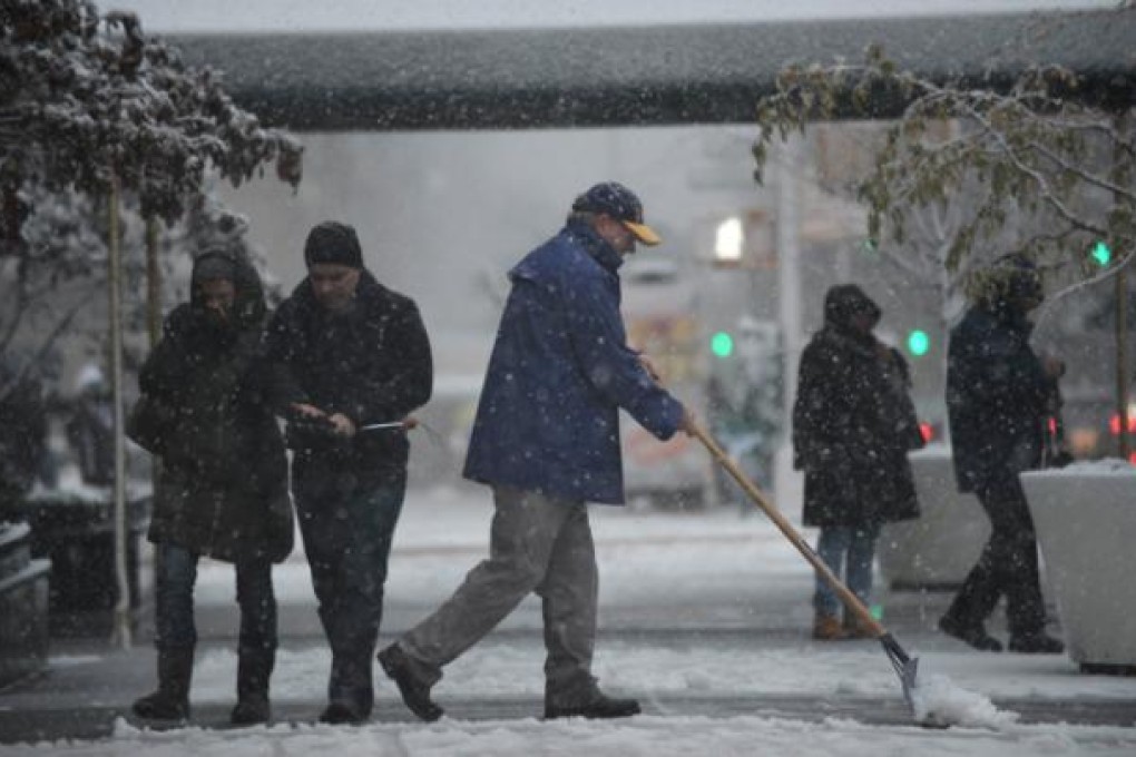 A man shovels snow from a sidewalk on Fifth Avenue in New York as a strong winter storm hits the northeast on Wednesday. Photo: AFP