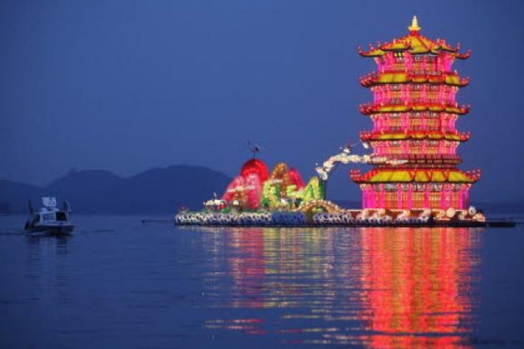 A tourist boat rows past a group of lanterns on Donghu lake in Wuhan. Photo: Reuters