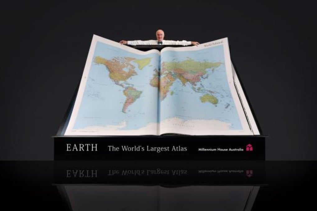 Gordon Cheers, managing director of Millennium House, with one of only 31 copies of the 150kg world atlas, Earth Platinum. Photo: Millennium House